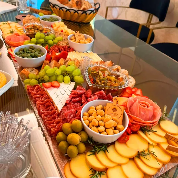 Mesa de frios com variedade de queijos, frutas e petiscos
