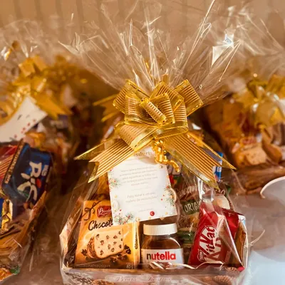 Cesta Encantada: Chocotone, biscoitinho gourmet, barra de chocolate Alpino, bolinho Bauducco, cookies, torrada de fermentação natural, snack crocante e muito mais